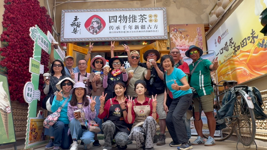 游客在和田团城玉都草集四物维茶店合影留念。